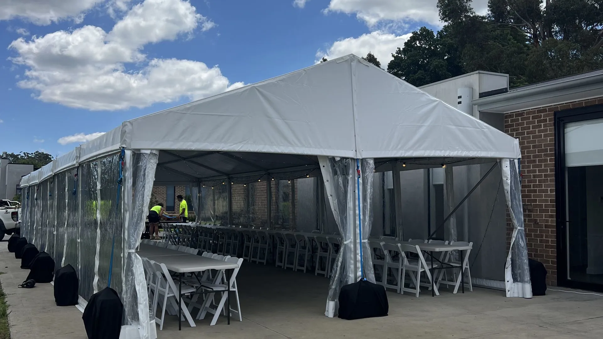 6m structure marquee with clear walls, banquet tables and americana chairs