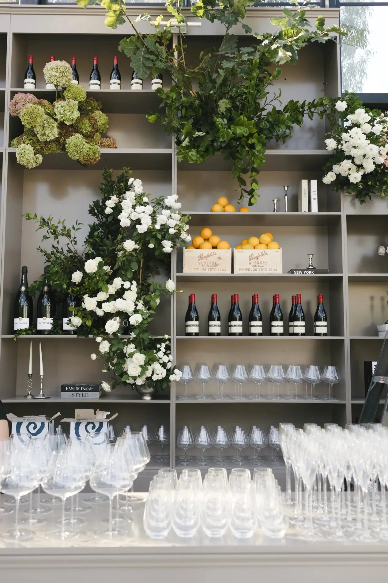 Styled wedding bar wall with wine, florals and glassware