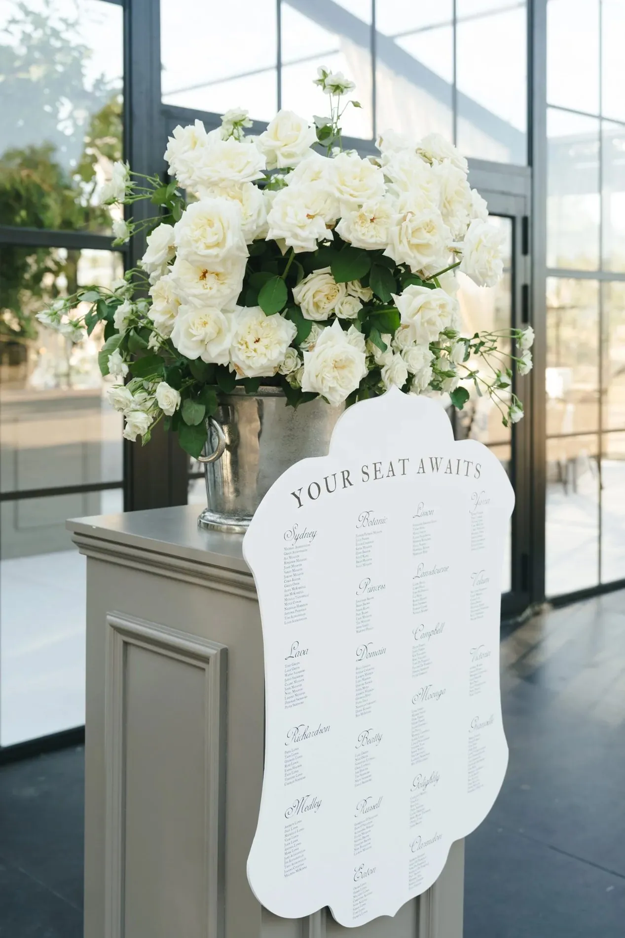 White rose floral arrangement and wedding seating chart